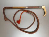 a wooden handle and a rope on a white surface