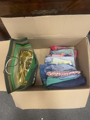 a box full of clothes and a bag with a gold spoon in it