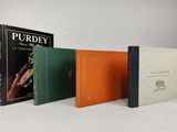 three books sitting on top of a white table next to each other