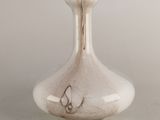 un vase en verre orné d'un papillon, posé sur une table