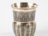 a silver cup sitting on top of a white table
