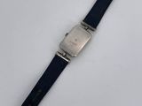 a close up of a watch on a white surface with a black strap