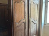 a large wooden armoire in the corner of a room