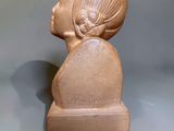 a small wooden statue of a woman on a table
