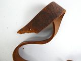 un morceau de métal rouillé sur une surface blanche