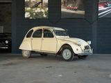 une petite voiture blanche garée dans un parking couvert