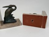 a statue of a bird on a bookend next to a brick