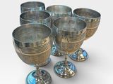six silver goblets sitting on top of each other on a white surface