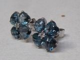 une paire de boucles d'oreilles en forme de fleurs en cristal bleu sur un fond blanc