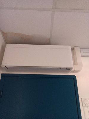 un climatiseur blanc posé sur une boîte bleue