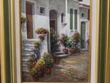 une peinture à l'huile représentant une maison avec des plantes en pot posée sur un chevalet