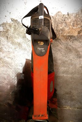 un aspirateur rouge et noir posé par terre