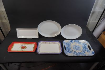 several plates and trays are sitting on a table in front of a black backdrop
