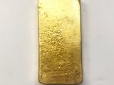 a close up of a gold bar on a white surface