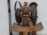 une statue représentant un homme assis sur un banc, avec un couteau, une fourchette et d'autres objets