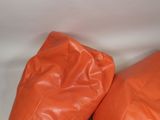 pair of orange leather bean bags on a white background