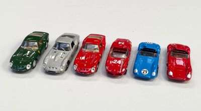 plusieurs petites voitures sont alignées sur une surface blanche