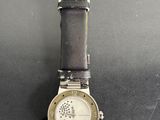 an image of a watch on a table with a black background