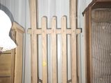 a wooden gate next to a bed in a room
