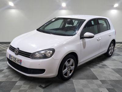 la volkswagen golf blanche est garée sur un carrelage à carreaux