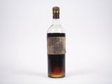une vieille bouteille d'alcool posée sur une surface blanche