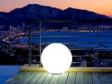 une boule blanche posée sur une terrasse en bois surplombant la ville