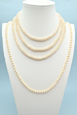 a white necklace with pearls on a mannequin