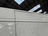 a white van parked in a building with a skylight above it