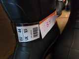 a pair of black boots with a price tag on them