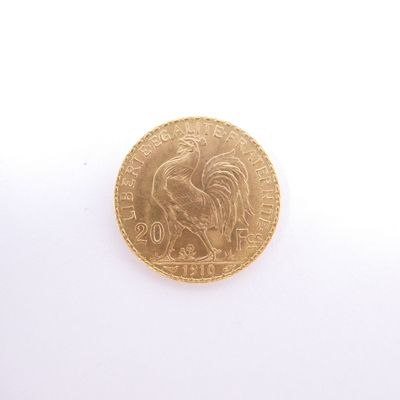 une pièce d'or représentant un coq sur un fond blanc