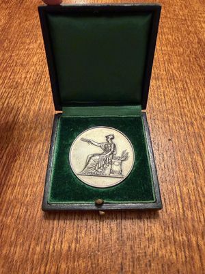 an image of a small box with a medal in it on a wooden table
