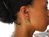 a woman that is wearing a pair of earrings