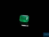 a green emerald stone on a black surface