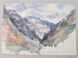 a watercolor painting of a mountain scene on a piece of paper