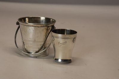 un seau en argent et une coupe en argent posés sur une table