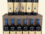 six bouteilles de vin rouge sont rangées dans une caisse en bois