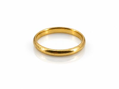 gros plan d'une bague en or sur une surface blanche
