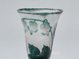 a close up of a glass vase with green leaves on it