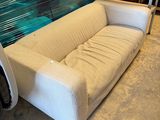 a white couch sitting in front of a large wall