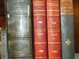 plusieurs vieux livres sont alignés sur une étagère dans une bibliothèque