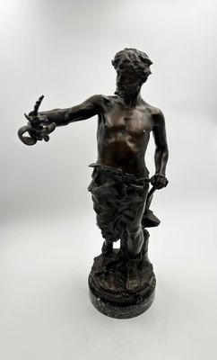 une statue antique en bronze représentant un homme tenant une épée