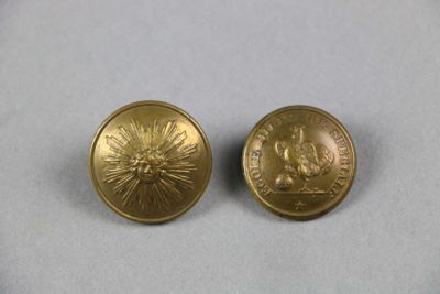 deux boutons dorés sur lesquels est représenté un soleil