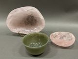 two bowls and a rock on a table with a green bowl