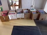 de nombreuses caisses de livres posées par terre dans la pièce