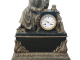 une statue d'un homme assis au sommet d'une horloge