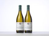 two bottles of white wine sitting on top of a table