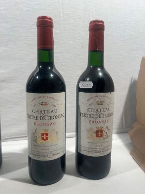 trois bouteilles de vin posées sur une table, à côté d'un sac en papier marron