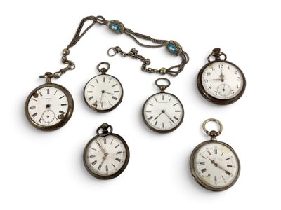 Plusieurs montres de poche anciennes sont exposées sur un support blanc