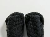 black slippers on a white surface with a white background