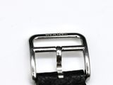 black leather watch strap with silver buckle on white surface
